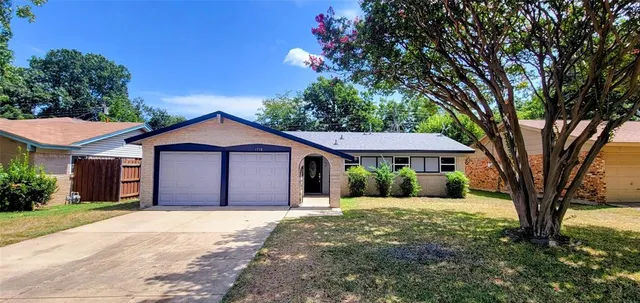 a view of a house with yard and a large tree