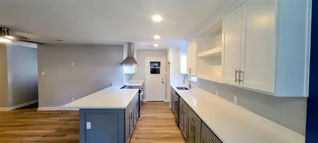a view of a kitchen with kitchen island a sink wooden floor and glass door