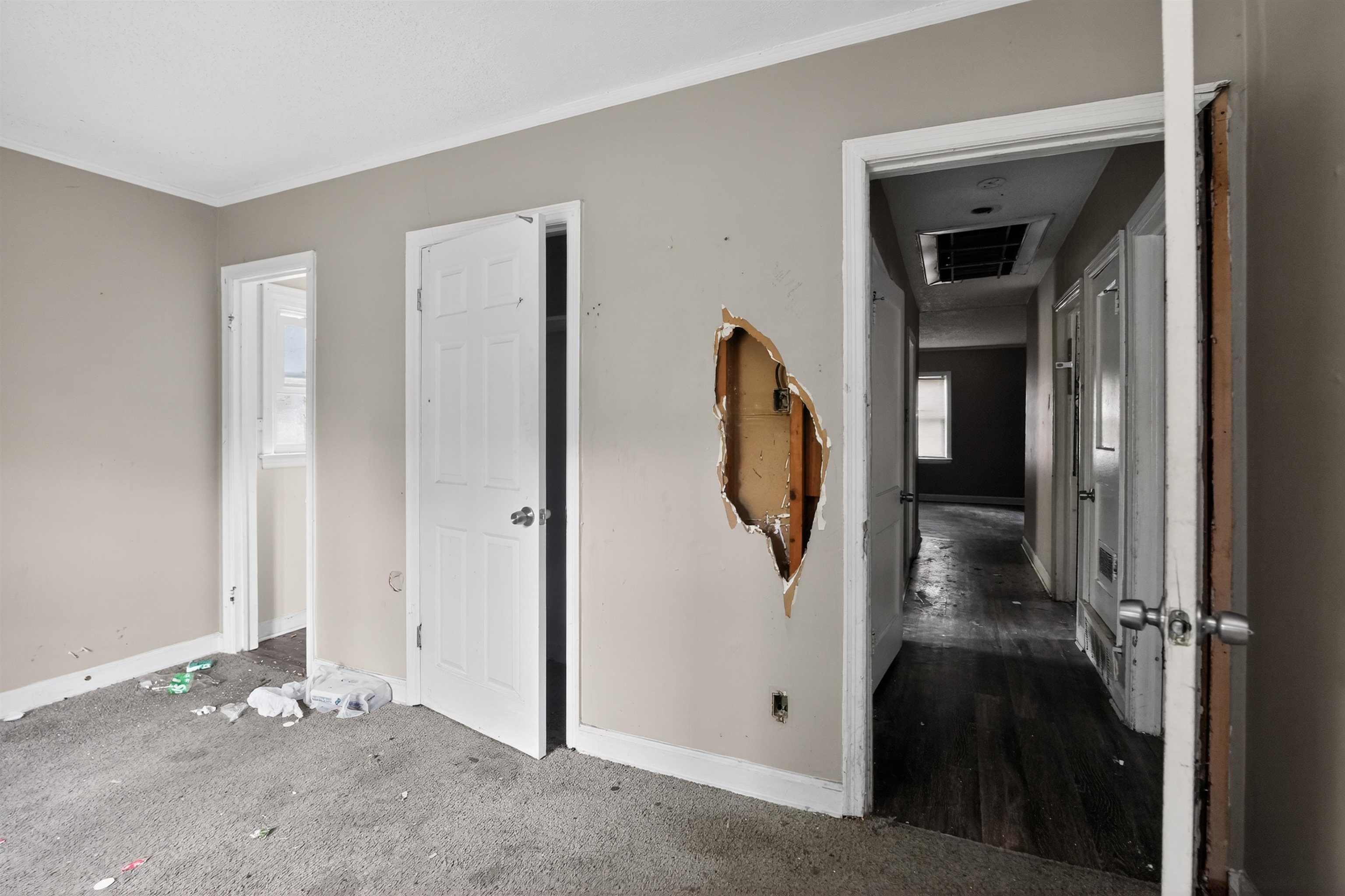 949 Sumter Street Memphis, TN 38122 - Photo 22 of 33 Interior space featuring light-toned walls, a white paneled door, and a hallway beyond with wood-finish flooring
