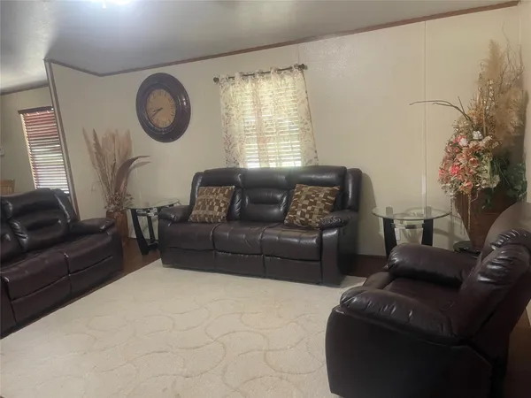 a living room with furniture a clock and a window