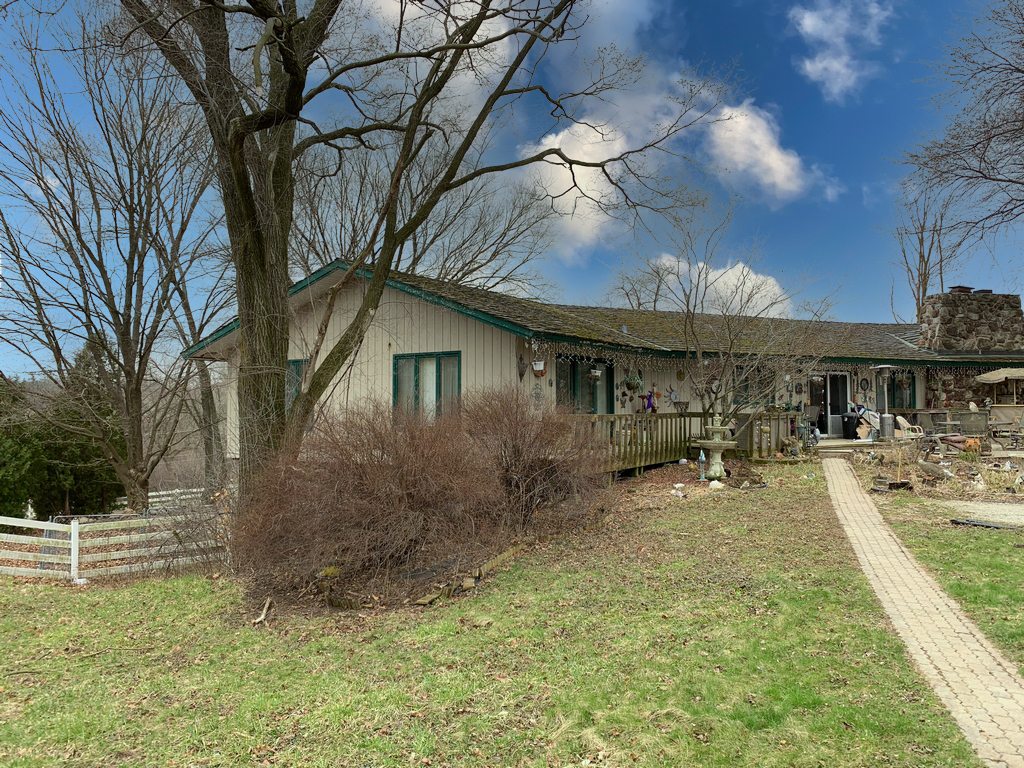 a view of a house with a yard patio and fire pit