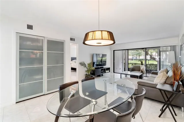 a dining room with furniture a chandelier and wooden floor