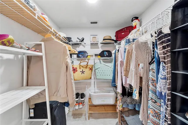 a view of walk in closet with clothes and shoes