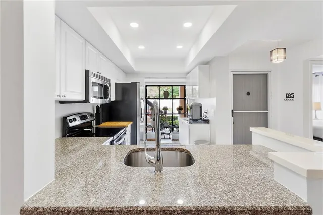a kitchen with sink a refrigerator and cabinets