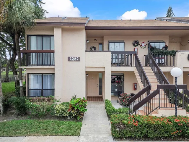 front view of house with a yard and potted plants