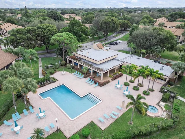 an aerial view of residential houses with outdoor space and lake view in back