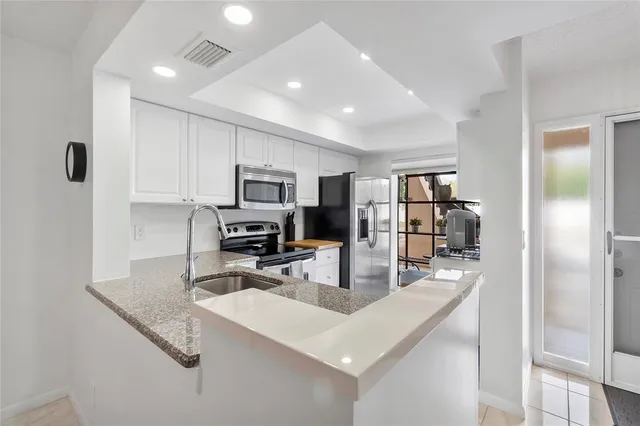 a kitchen with stainless steel appliances granite countertop a sink refrigerator and microwave