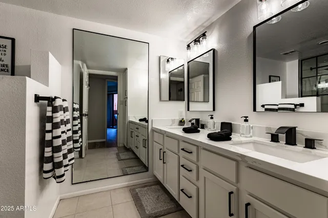 a spacious bathroom with double vanity and mirrors