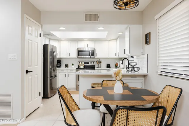 a kitchen with granite countertop white cabinets and refrigerator
