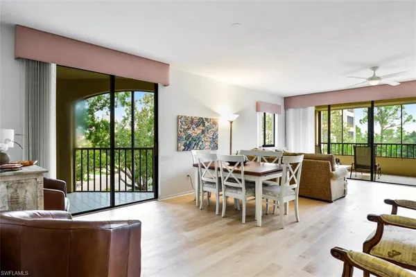 a dining room with furniture and a floor to ceiling window