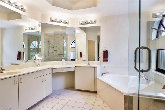 a large bathroom with a double vanity sink mirror and bathtub
