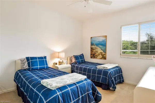 a bedroom with two beds and a window