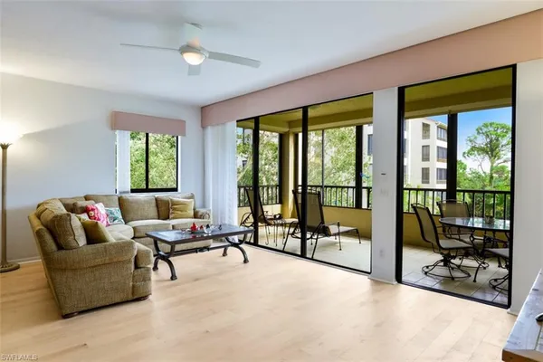 a living room with furniture and floor to ceiling window