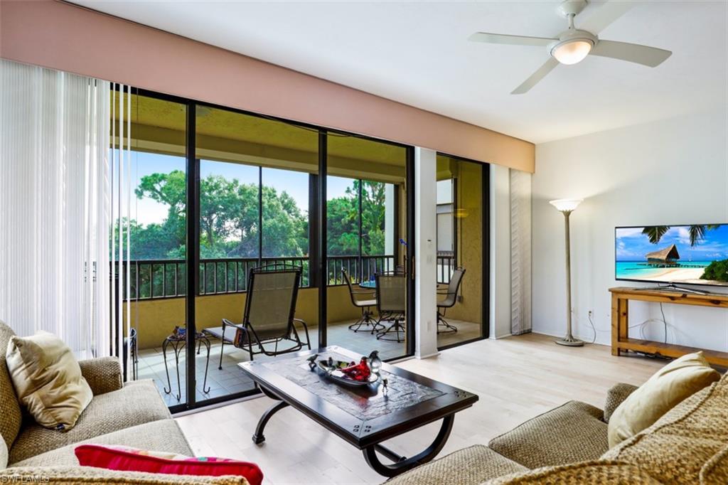 6500 Valen Way, Unit A305 Naples, FL 34108 - Photo 7 of 22 a living room with furniture and a floor to ceiling window
