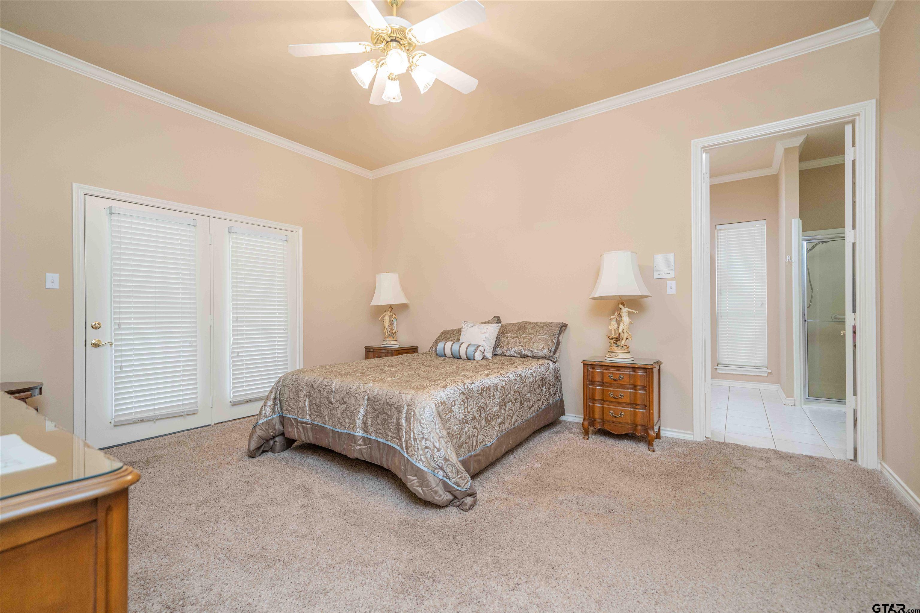 2215 Homestead Lane Tyler, TX 75701 - Photo 14 of 31 a spacious bedroom with a bed and a chandelier