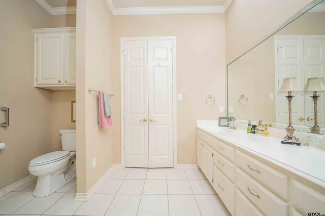 a spacious bathroom with a double vanity sink toilet and a tub