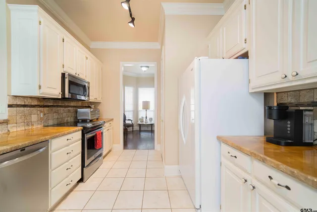 a kitchen with granite countertop a sink a stove top oven and cabinets