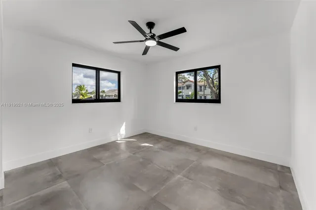an empty room with window and ceiling fan
