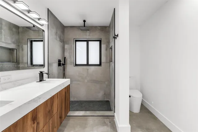 a bathroom with a sink a toilet and shower