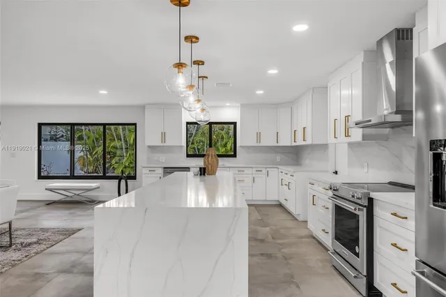 a large kitchen with stainless steel appliances lots of counter space and a sink