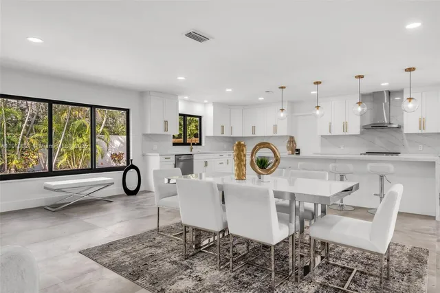 a kitchen with a dining table chairs and refrigerator