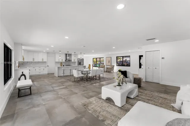 a living room with furniture and kitchen view