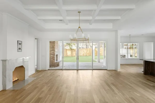 a view of empty room with wooden floor and fireplace