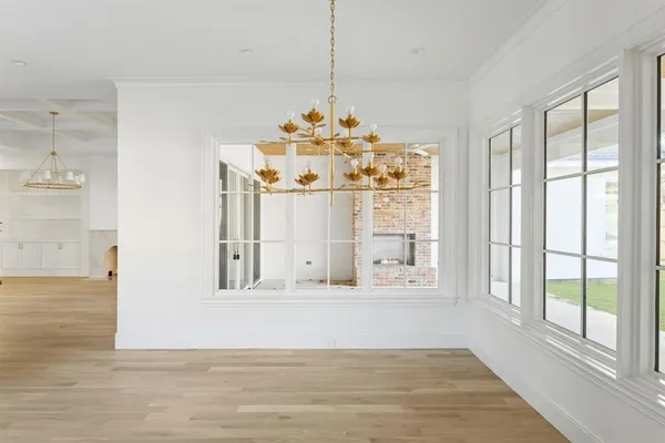 a view of a livingroom with wooden floor windows and a chandelier