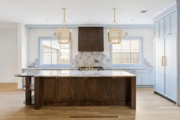 a kitchen with granite countertop a sink cabinets and wooden floor