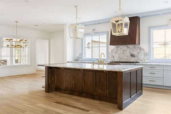 a kitchen with granite countertop a sink cabinets and wooden floor