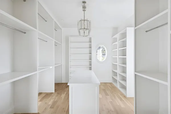 a view of a hallway with wooden floor and windows