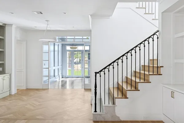 a view of staircase with lots of white walls and a chandelier