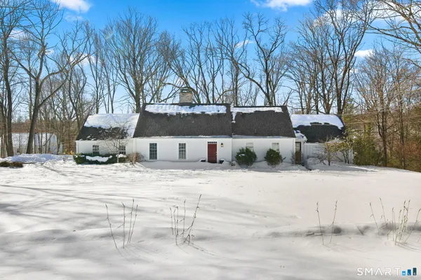 a front view of a house with a yard covered in snow