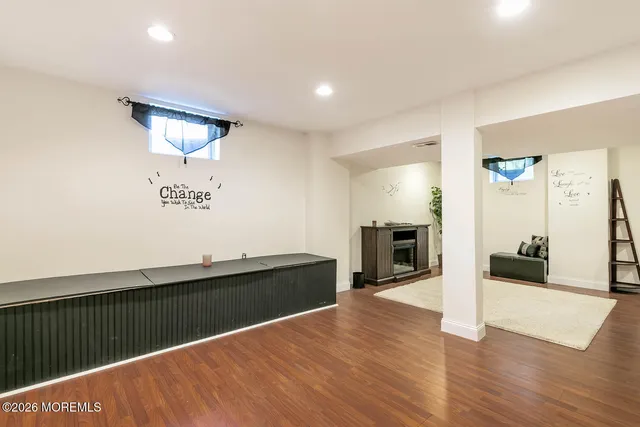 a view of a living room with wooden floor and a fireplace