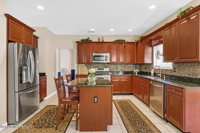 a kitchen with stainless steel appliances granite countertop a refrigerator stove microwave and sink