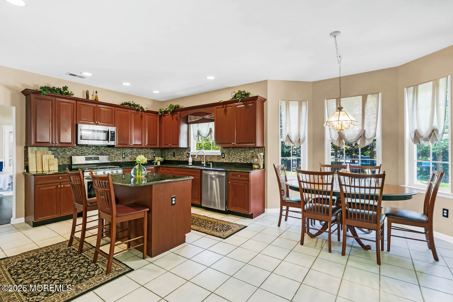 46 Woodview Drive Howell, NJ 07731 - Photo 5 of 17 a kitchen with stainless steel appliances granite countertop a stove a refrigerator a kitchen island a table and chairs