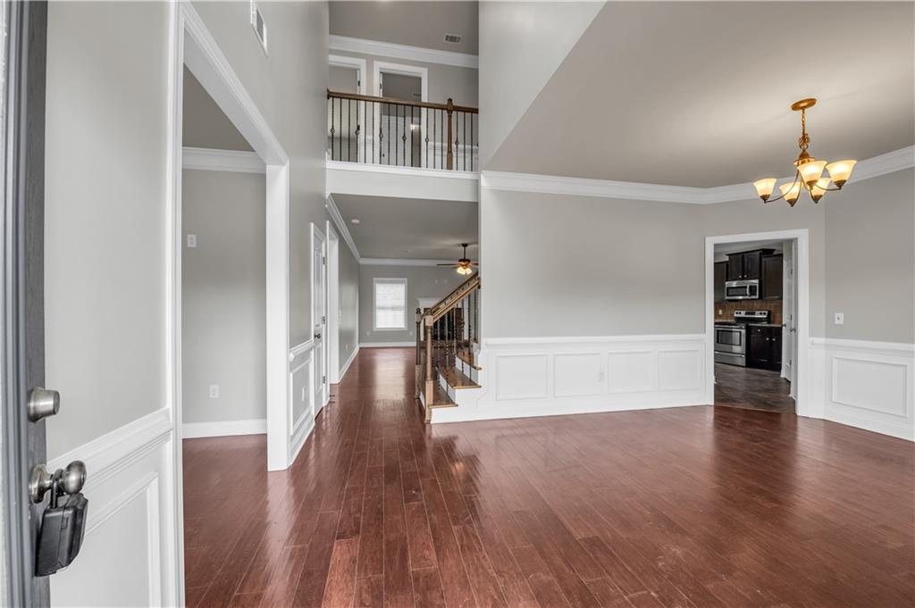 2626 Holden Spring Drive Dacula, GA 30019 - Photo 13 of 62 a view of a hallway with wooden floor and a kitchen