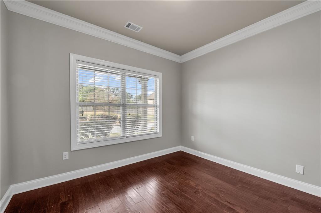 2626 Holden Spring Drive Dacula, GA 30019 - Photo 18 of 62 a view of an empty room with wooden floor and a window