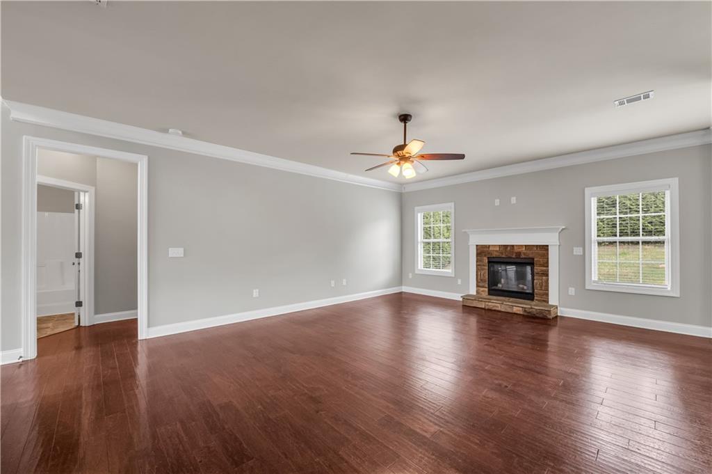 2626 Holden Spring Drive Dacula, GA 30019 - Photo 23 of 62 a view of an empty room with wooden floor fireplace and a window
