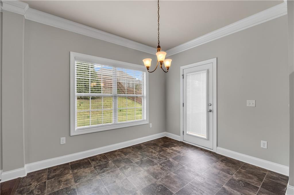 2626 Holden Spring Drive Dacula, GA 30019 - Photo 29 of 62 an empty room with chandelier fan and windows