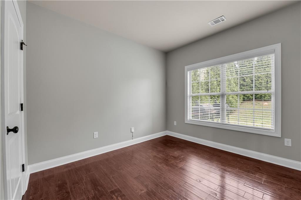 2626 Holden Spring Drive Dacula, GA 30019 - Photo 35 of 62 a view of an empty room with wooden floor and a window