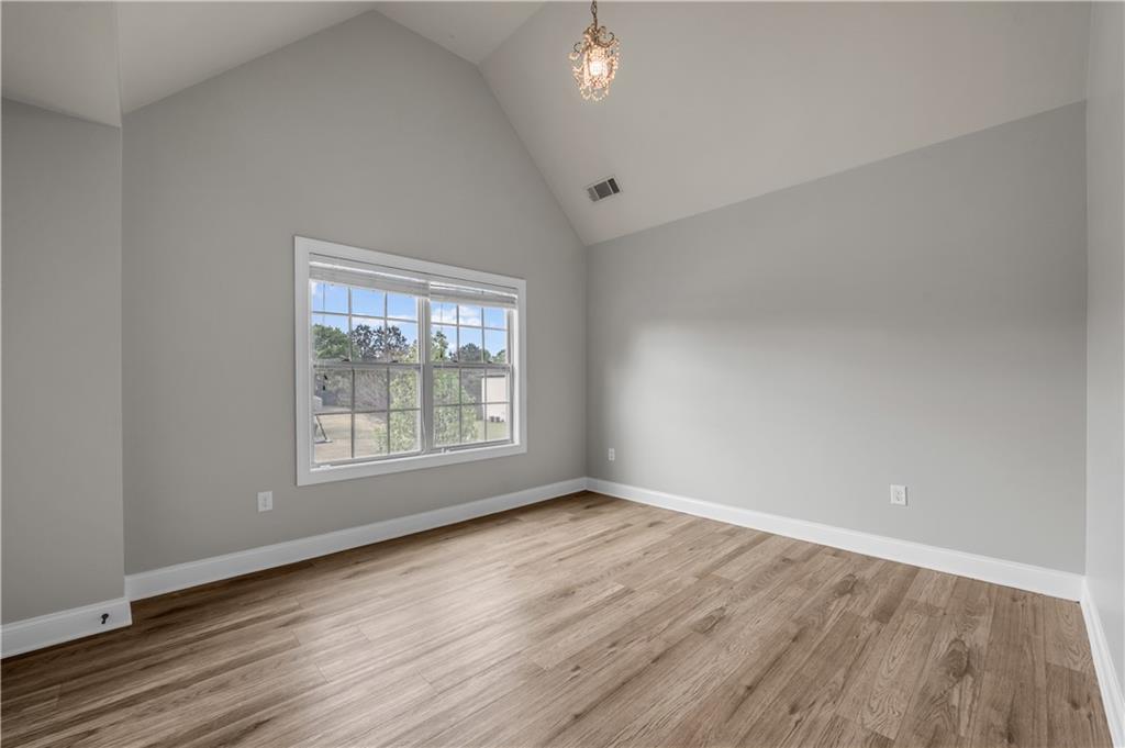 2626 Holden Spring Drive Dacula, GA 30019 - Photo 40 of 62 a view of an empty room with wooden floor and a window