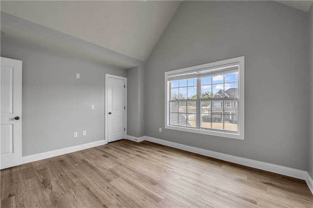 2626 Holden Spring Drive Dacula, GA 30019 - Photo 41 of 62 a view of an empty room with wooden floor and a window