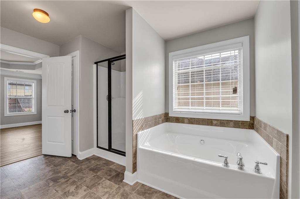 2626 Holden Spring Drive Dacula, GA 30019 - Photo 53 of 62 a bathroom with a bathtub and a window