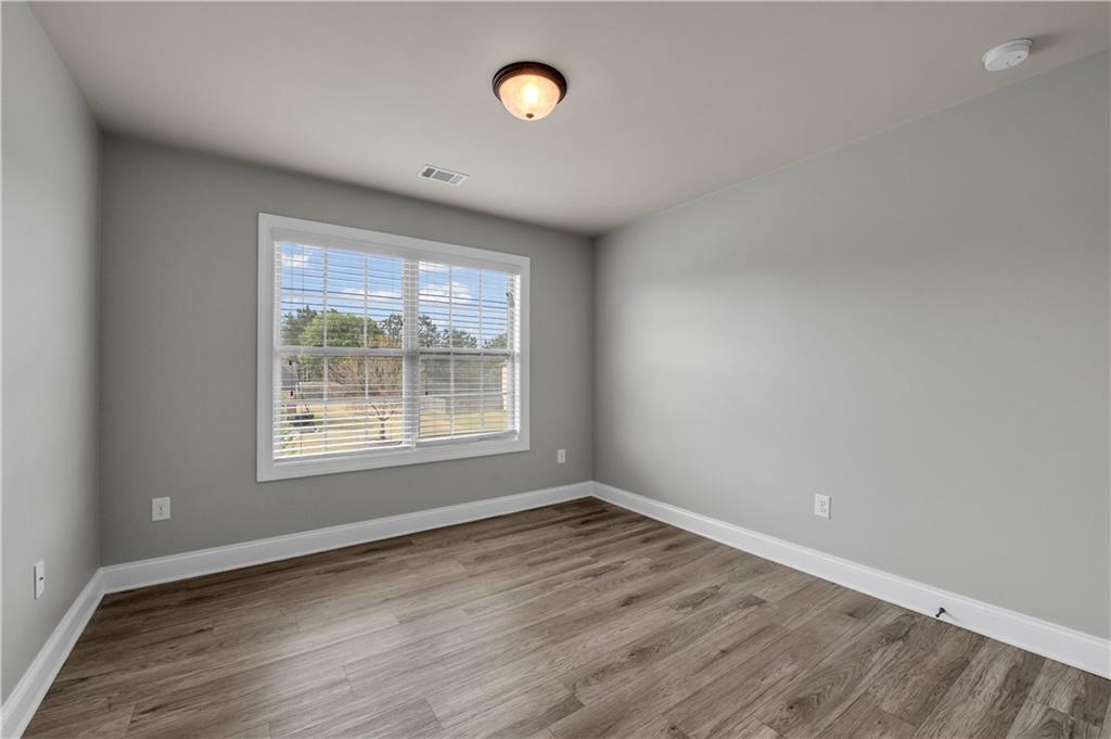 2626 Holden Spring Drive Dacula, GA 30019 - Photo 55 of 62 an empty room with wooden floor and windows