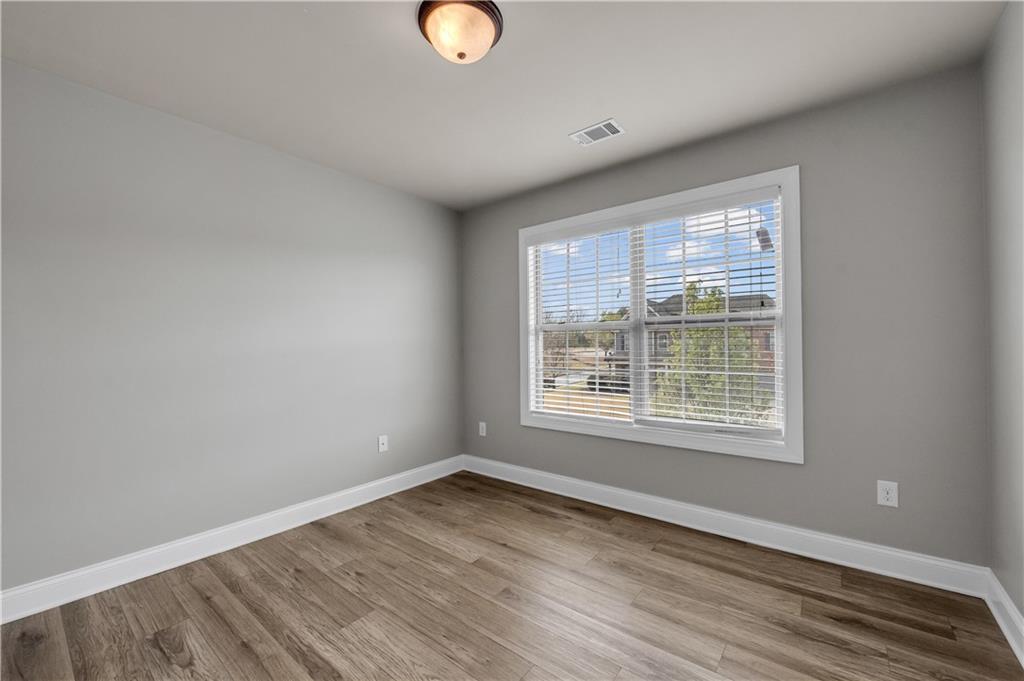 2626 Holden Spring Drive Dacula, GA 30019 - Photo 56 of 62 an empty room with wooden floor and windows