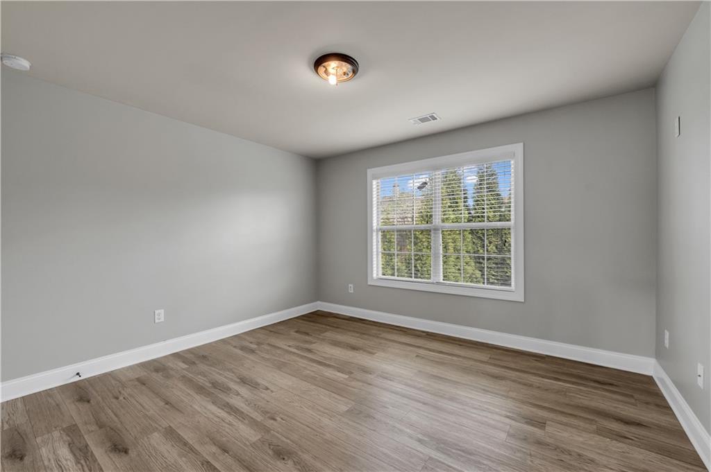 2626 Holden Spring Drive Dacula, GA 30019 - Photo 58 of 62 a view of an empty room with wooden floor and a window