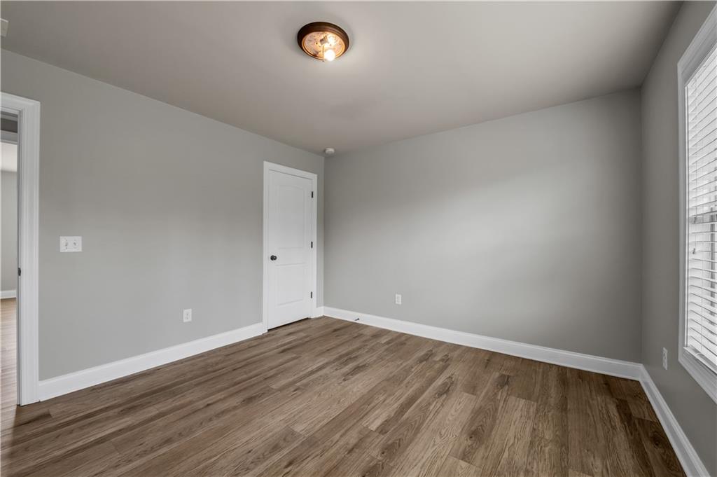 2626 Holden Spring Drive Dacula, GA 30019 - Photo 59 of 62 an empty room with wooden floor and windows