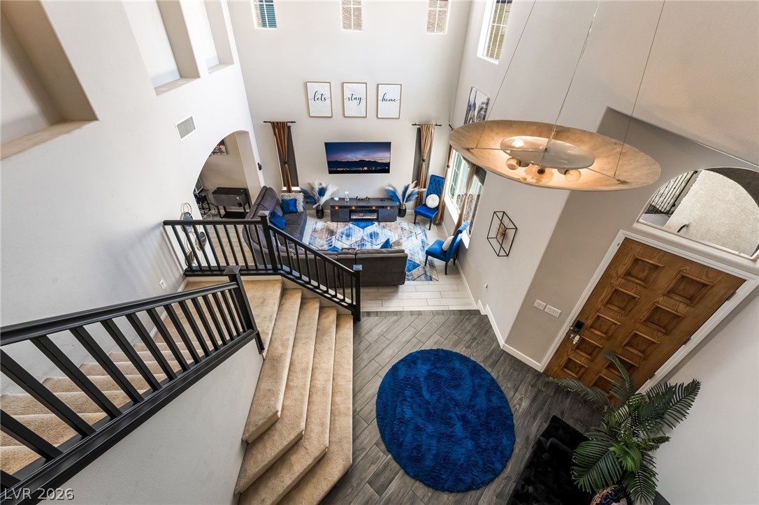 8358 Nelson Ridge Lane Las Vegas, NV 89178 - Photo 18 of 43 Enter into a soaring, light-filled living area featuring a grand staircase and elegant hardwood flooring.