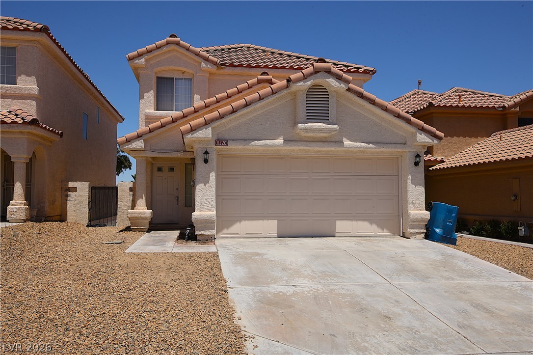 A charming stucco exterior welcomes with a two-car garage and a classic tile roof.